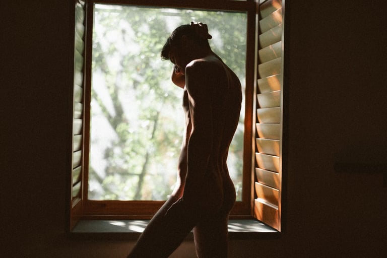 Photo boudoir homme nu en studio, lumière tamisée — Belle Tronche Montréal - Silhouette intérieur, porte