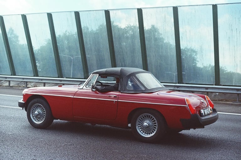 Red MGB Roadster driving on a highway in the Netherlands. Unedited 35mm film SOOC photography.
