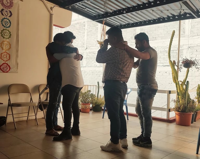 Cuatro hombres en pareja se abrazan en un ejercicio de Constelación Familiar en Oaxaca de Juárez