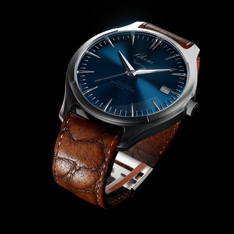 Luxury silver wristwatch with a sunray blue dial and a textured brown leather strap against a black