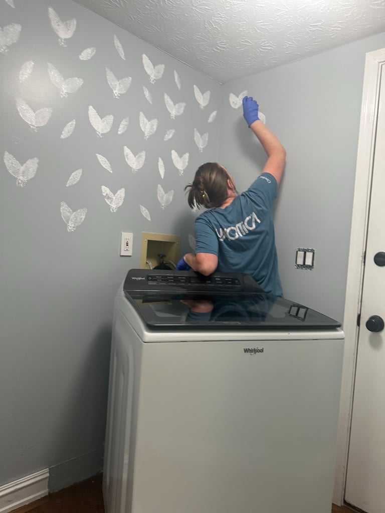 White sponge-stamped butterfly pattern on gray laundry room wall