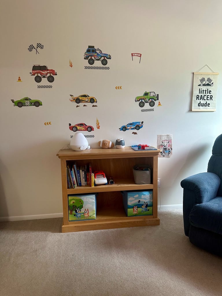 Peel-and-stick race car and monster truck wall decals in a car-themed toddler boy room
