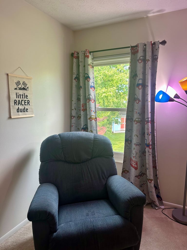 Car and truck print curtains in a toddler boy's car-themed bedroom