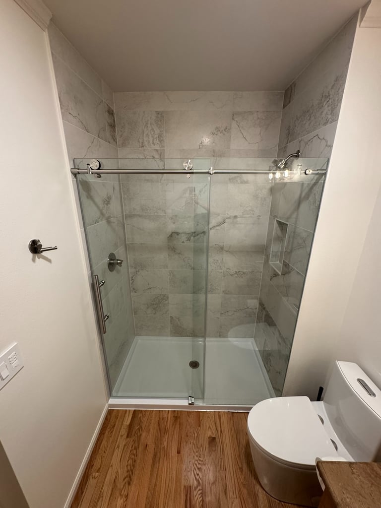 Shower Glass Installation on Modern bathroom renovation new custom tile and fiberglass pan Snohomish