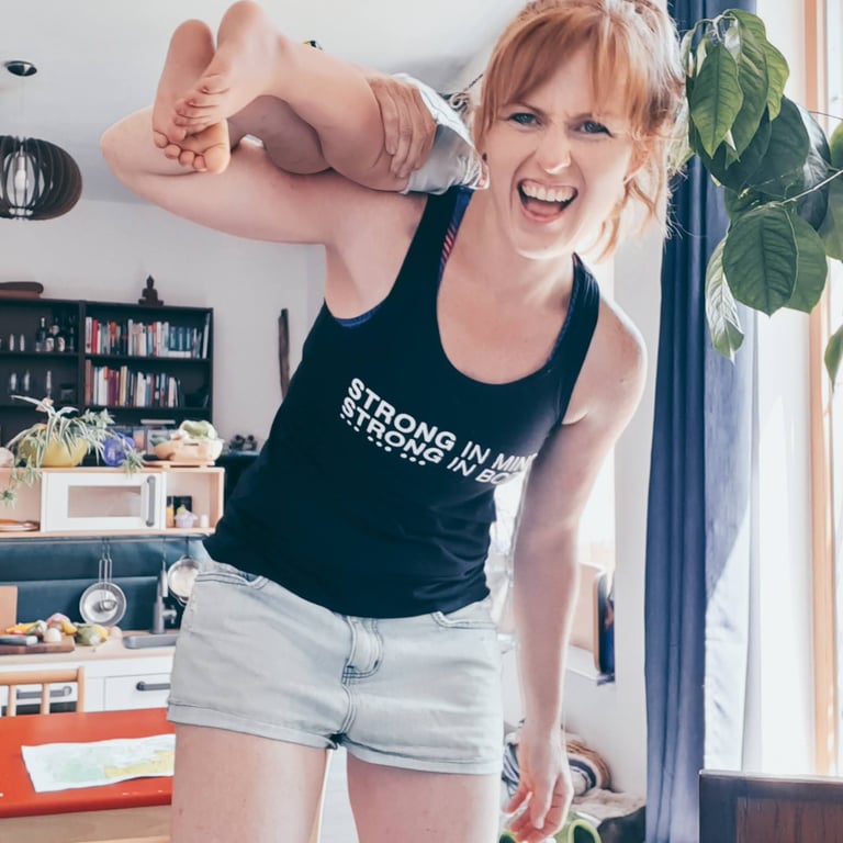 image shows Kaye lifting her daughter over her shoulder, laughing.