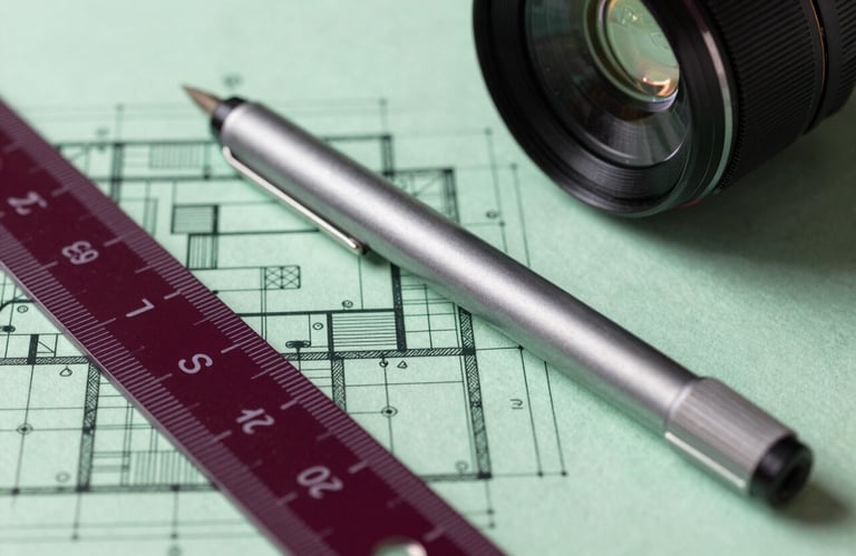 Close-up macro shot of a complex architectural blueprint on parchment green paper. A professional drafting pen and a deep carmine red scale ruler lie across the plans. Sharp details, soft lighting.