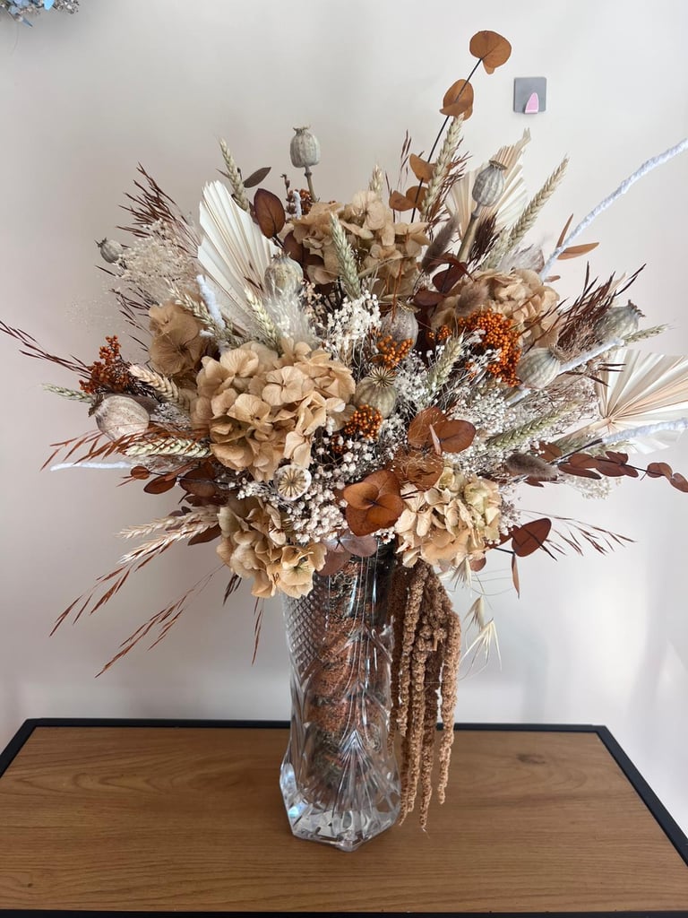 Centro de mesa com arranjo de flores secas em tons neutros para decoração