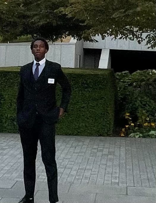 a man in a suit and tie standing in front of a building