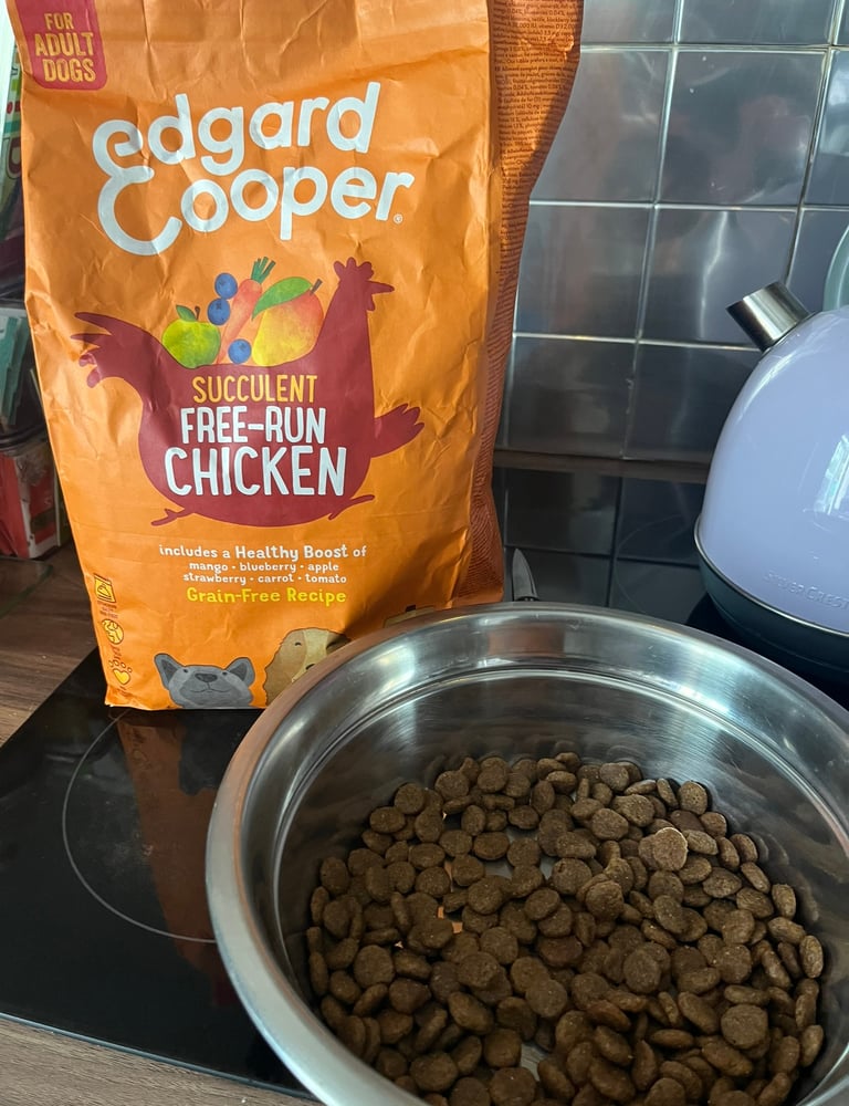 Close-up of Edgard & Cooper kibble in a dog bowl with packaging in the background