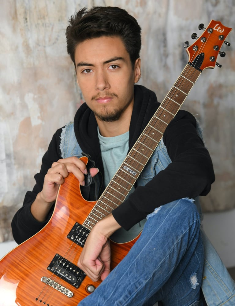 Me sitting down while holding my guitar.