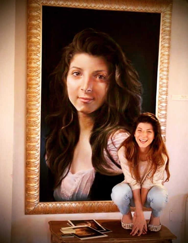 Photo of a girl posing in front of a portrait of herself