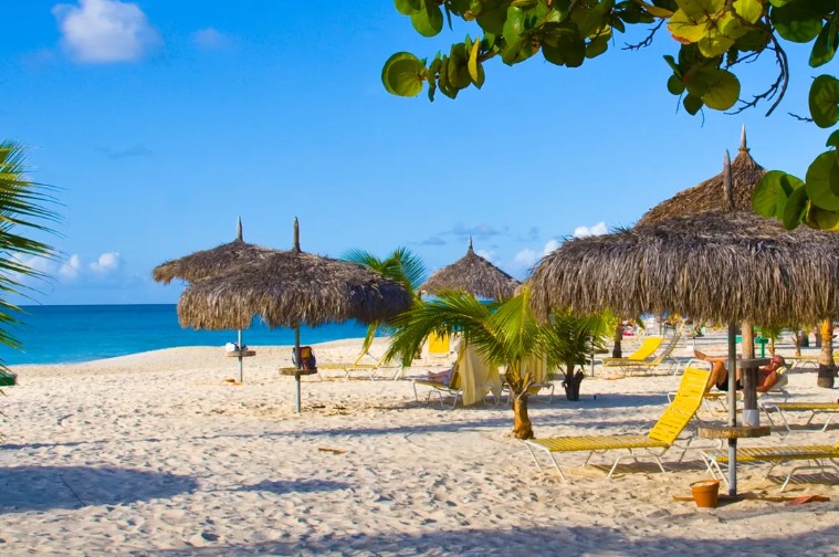 a beach with chairs and umbrellas on the sand
