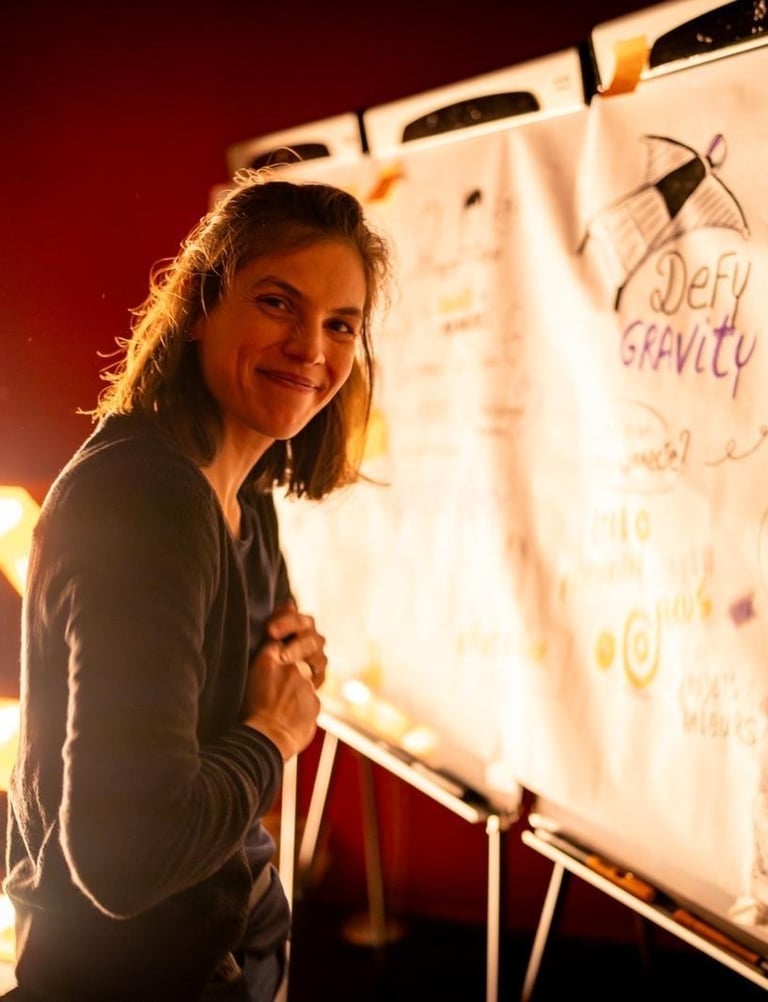 Val happily standing in front of her drawing