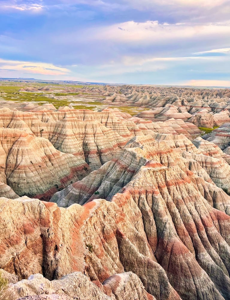Vibrant layered rock formations and jagged ridges under a blue sky at Badlands National Park.
