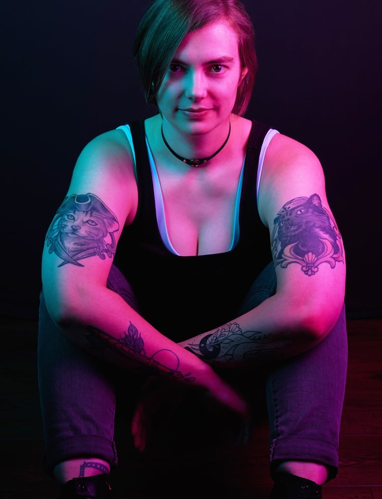 a woman with cat tattoos on her both arms with pink lighting on her skin