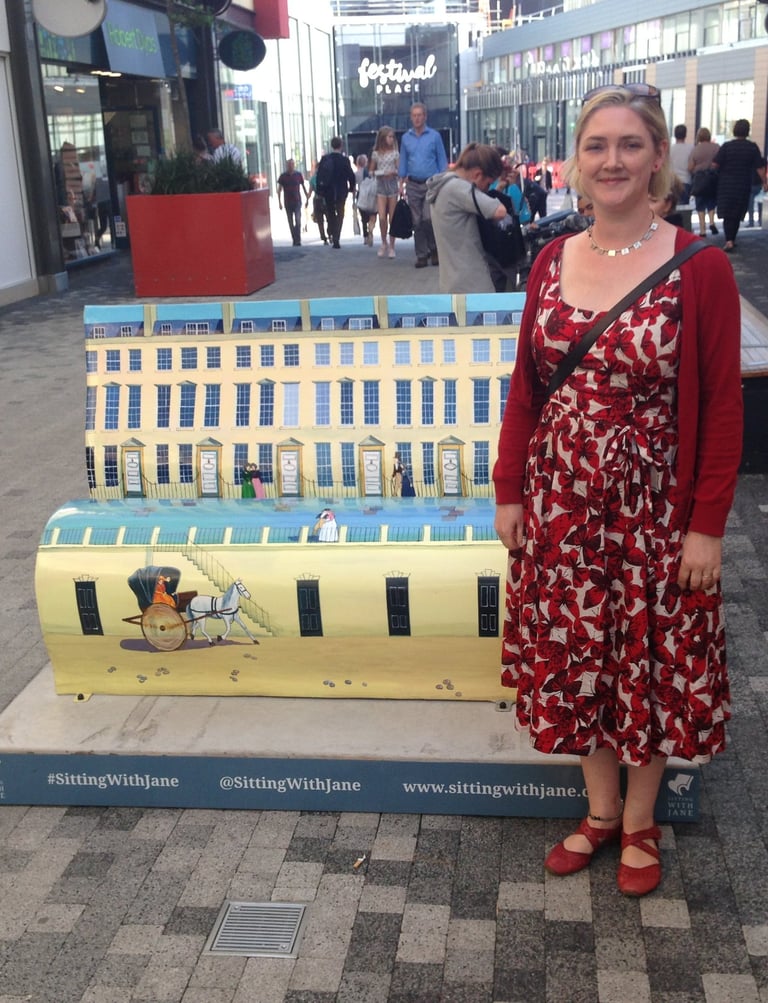 Laura Fearn with her street sculpture book bench featuring Bath Street scenes.