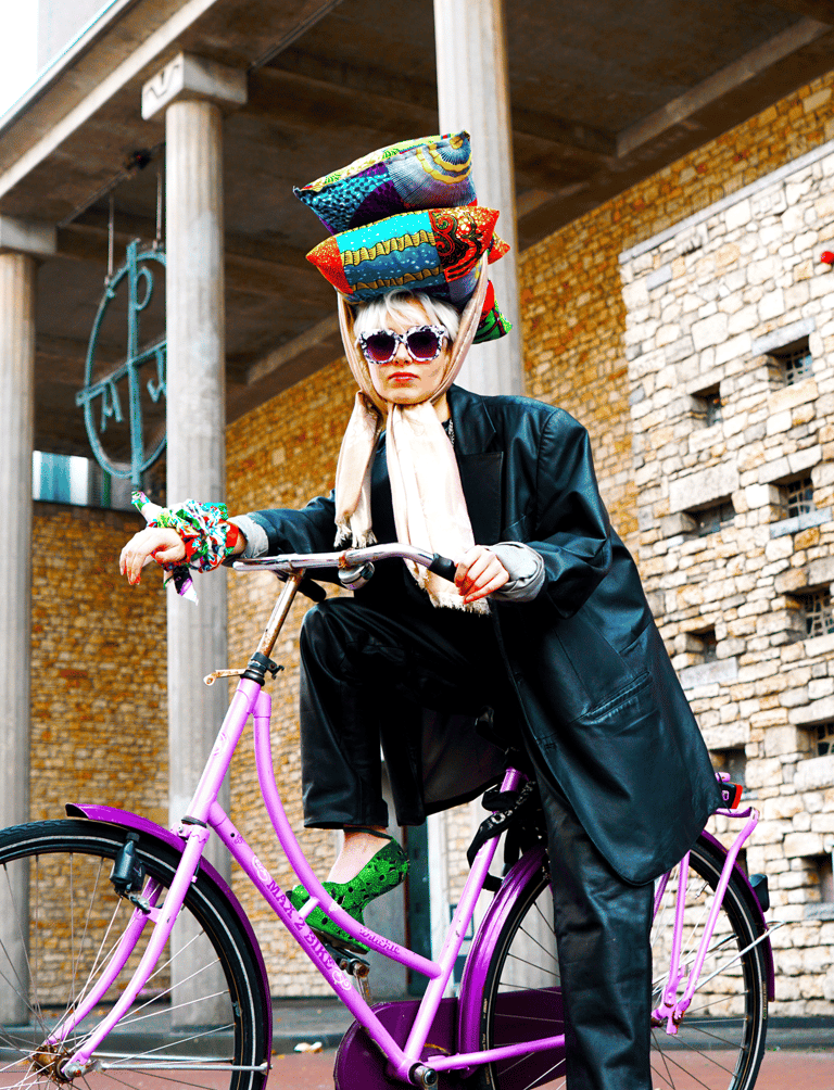 a woman in a hat and sunglasses is posing for a photo