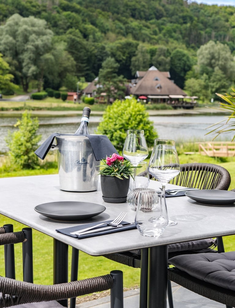 Eleganter Outdoor-Esstisch zum Mittagessen mit Weinkühler und Blick auf See und Hügel.