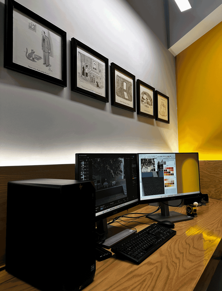 Área de trabajo con iluminación indirecta, doble monitor y muro amarillo decorado | KARÄNA