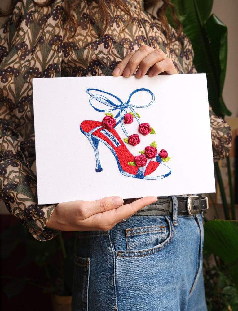 a woman holding a card with a drawing of a shoe