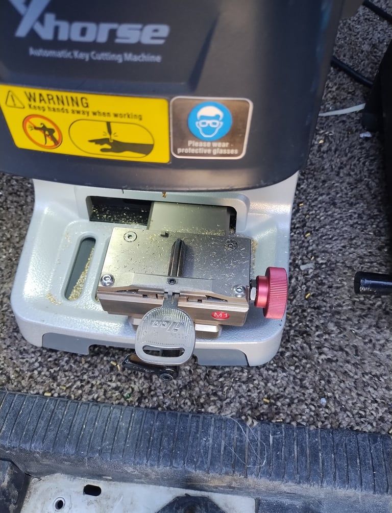 machine cutting a new car key replacement