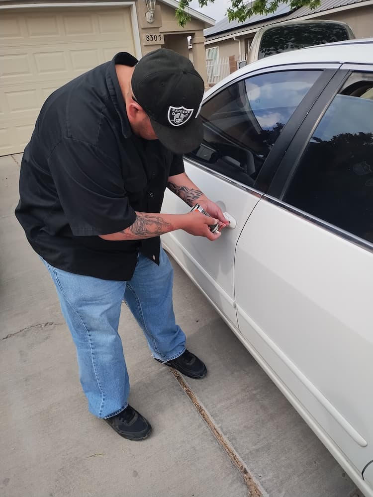 a man in a black shirt is unlocking a car