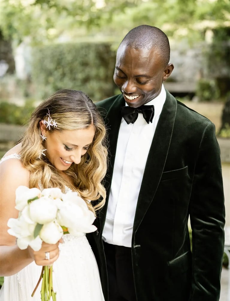 Groom walking around bride to admire her wedding dress during their first look