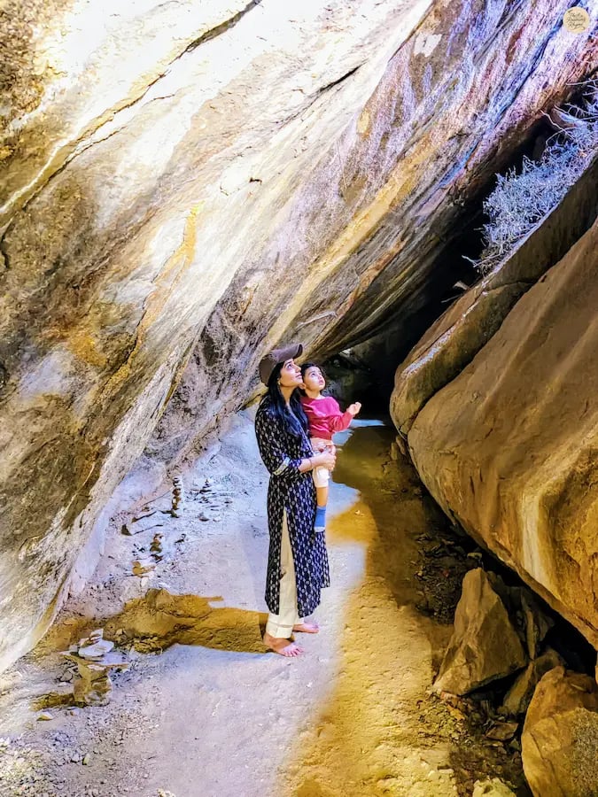 Mother and child exploring Vali Cave in Hampi, steeped in legendary tales.