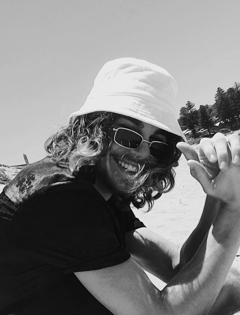 a man in a hat and sunglasses on a beach