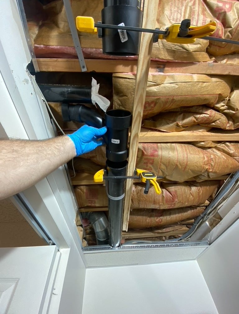 plumbing repair on a 3 inch drain line tee in basement ceiling with insulation