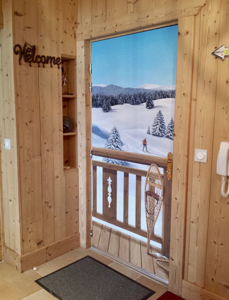 Hall d'entrée avec trompe-l'oeil sur porte d'entrée. Paysage neige, skieur, raquettes neige, bois