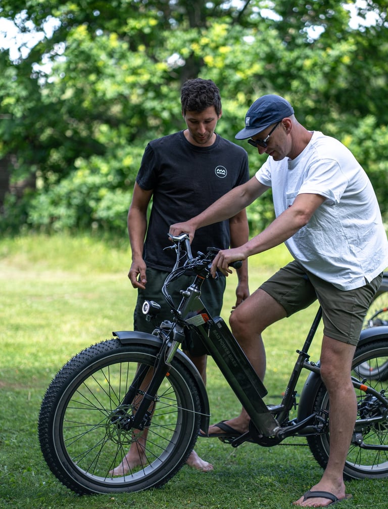 a man standing next to a man on a electric bike