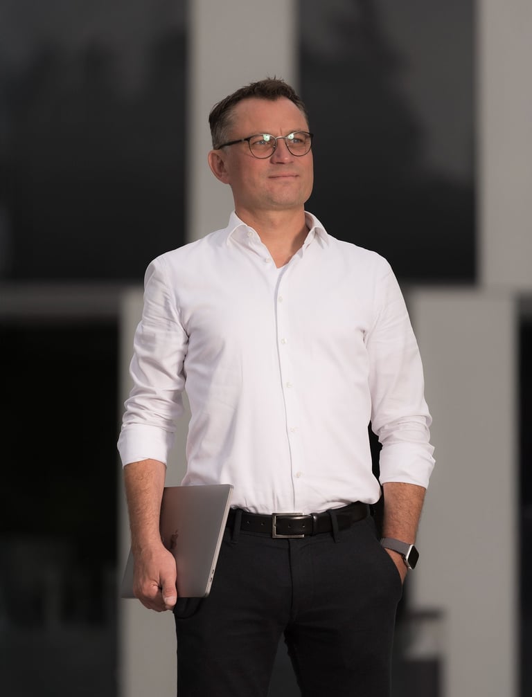 Unternehmer mit Laptop vor moderner Architektur in Oranienburg – Businessportrait bei Abendlicht