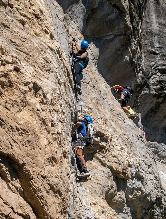 personas escalando una via ferrata