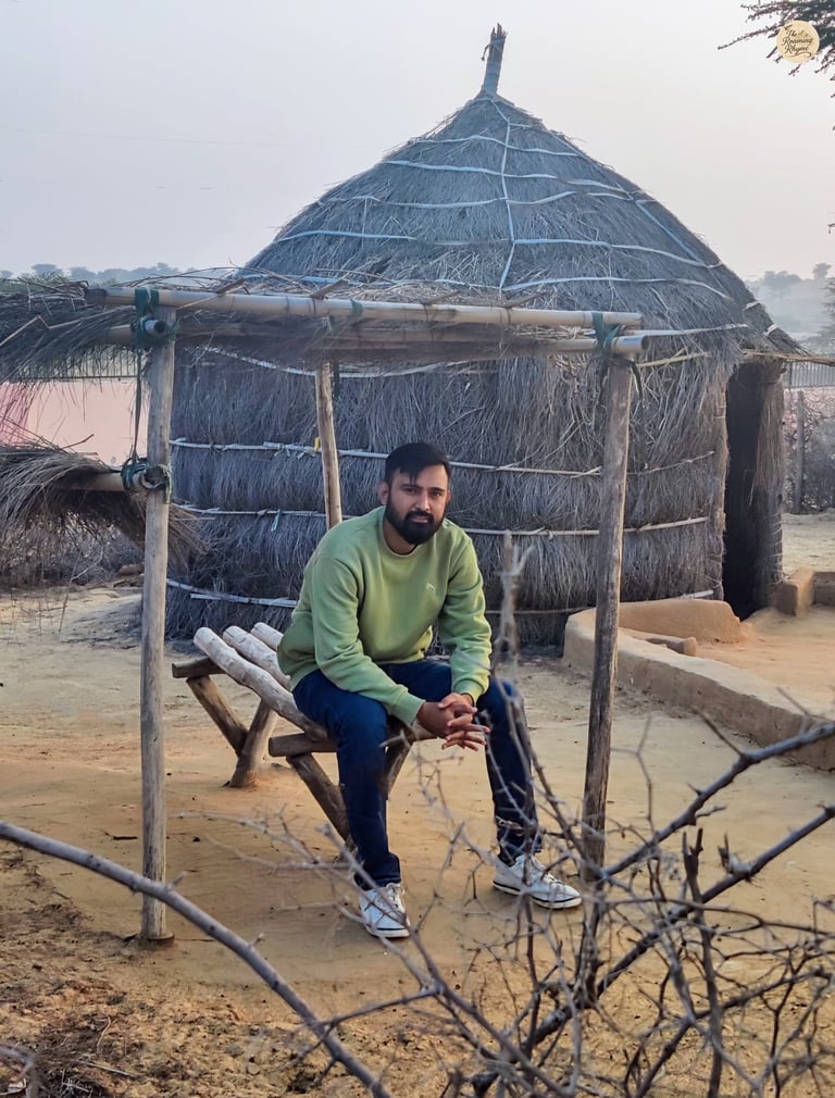 Sitting by a traditional Rajasthani hut in Raisar dunes - living the desert calm of Bikaner.