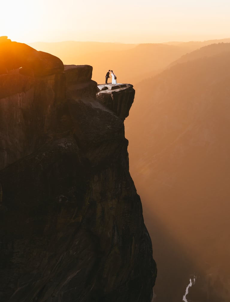 Couple standing on Glacier Point in Yosemite at Golden Hour