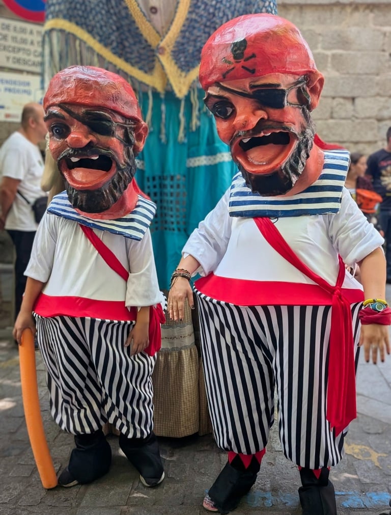 Dos cabezudos con grotescos disfraces de piratas y cabezas enormes.