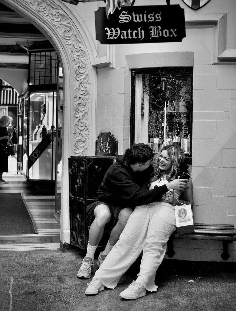 Young couple on a city bench having a laugh