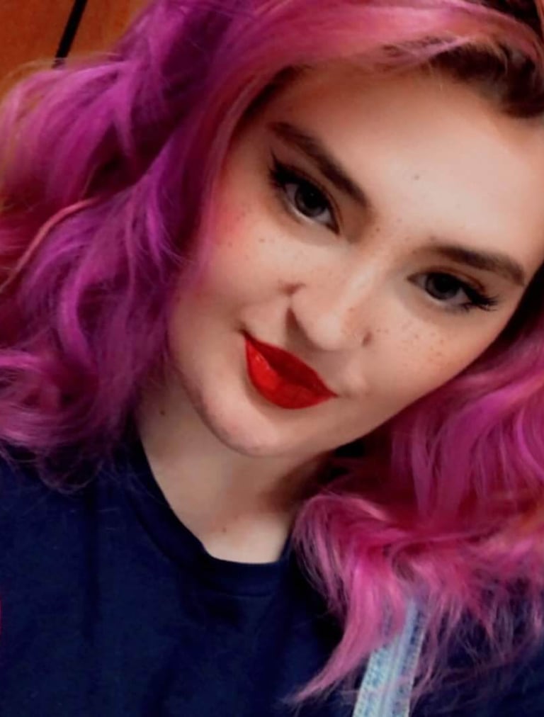a woman with pink hair and a blue shirt
