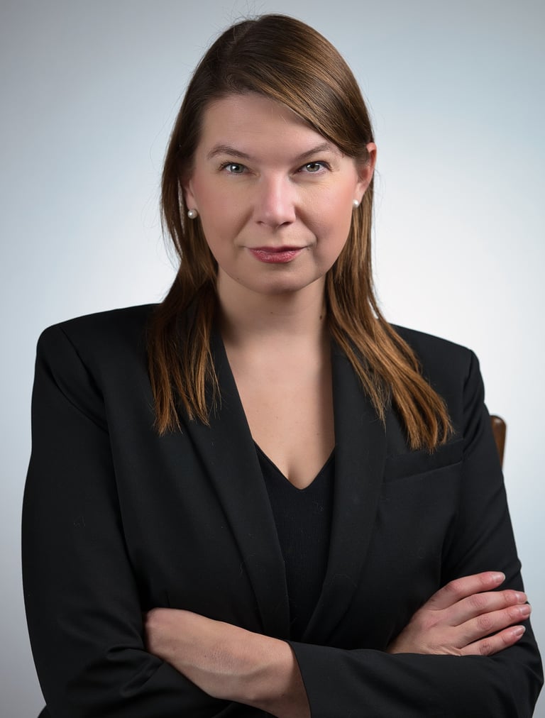 a woman in a black suit and a black shirt looking confident