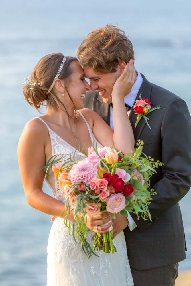 bride & groom holding bouquet on cliffside of cuvier park, la jolla