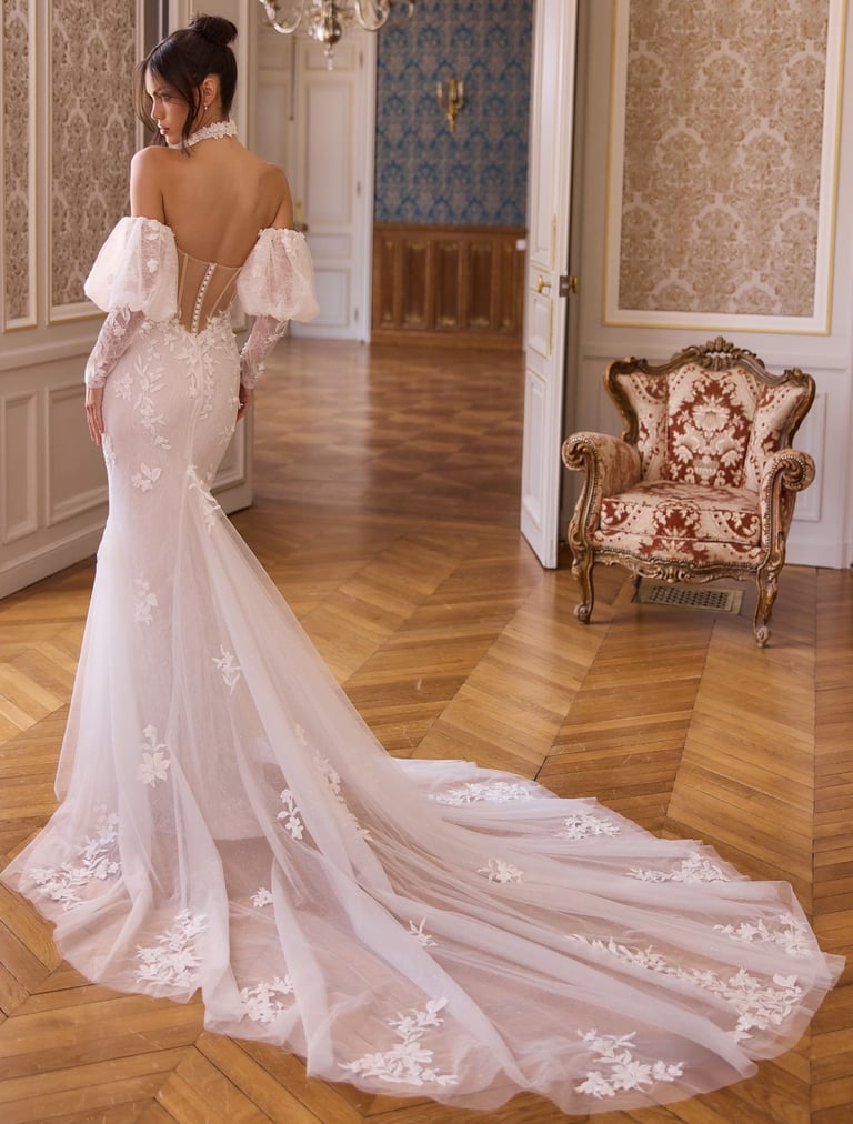 Elegant mermaid wedding dress with lace floral details, off-the-shoulder sleeves, and a long tulle train.