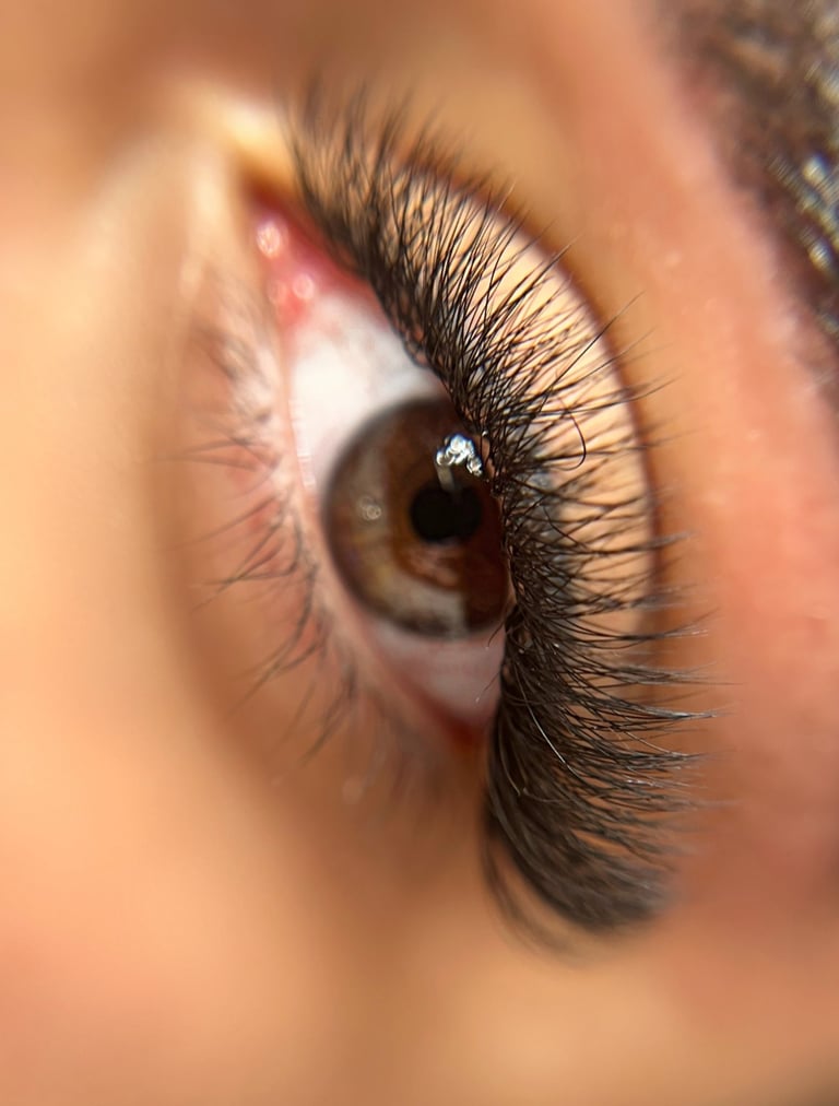 a close up of a woman's eye with eyelash extensions. Made by destheticsalon