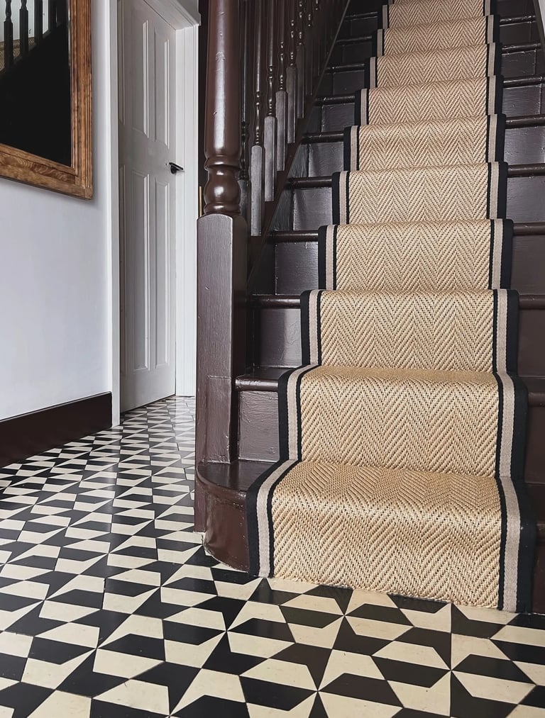 a staircase with a black and white carpet and a black and white carpet
