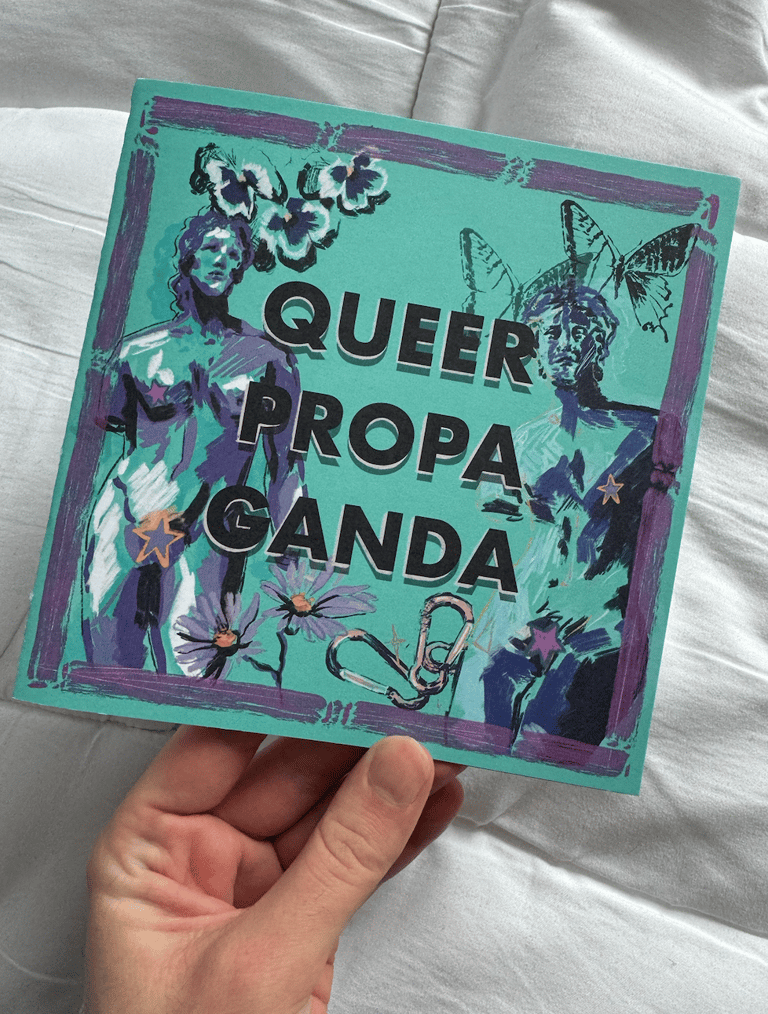A photo of a zine cover, cover illustration shows two androgynous statues, text says 'queer propaganda'.