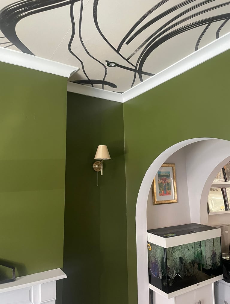 deep green walls, papered ceiling and fish tank