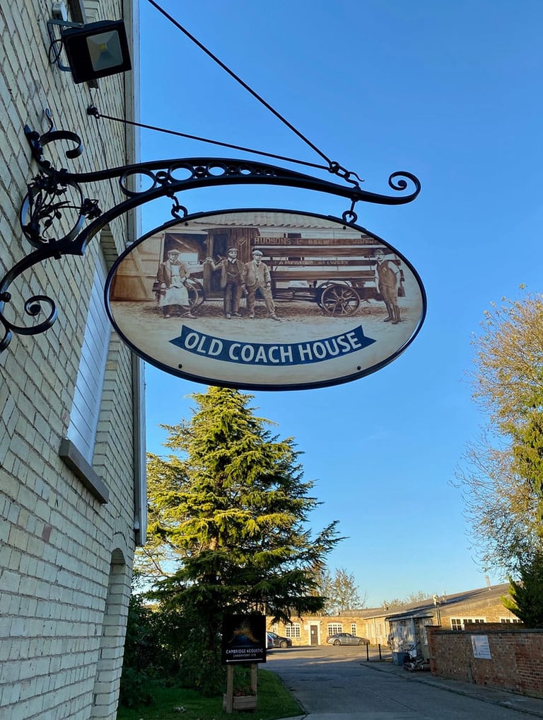 Cast iron pub sign with painting depicting former brewery staff