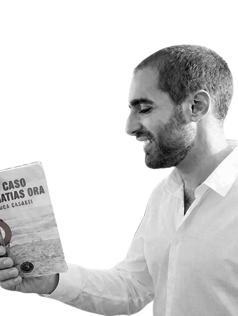 L’autore Luca Casadei sorride mentre tiene in mano il suo libro