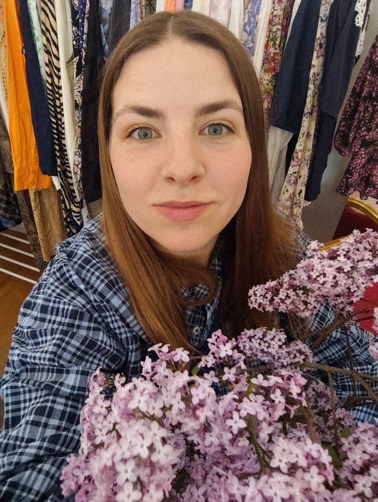 kobieta z kwiatami bzu na tle ubrań