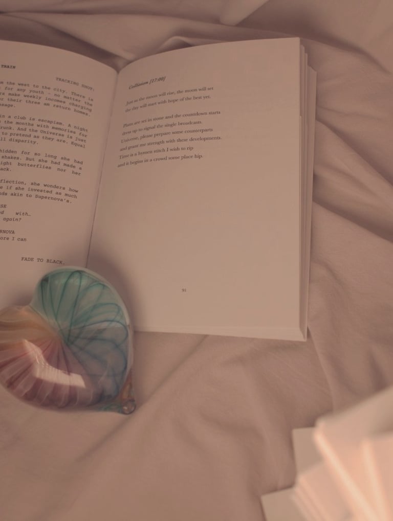 J.R. Sonder's book held apart with a rainbow glass heart.